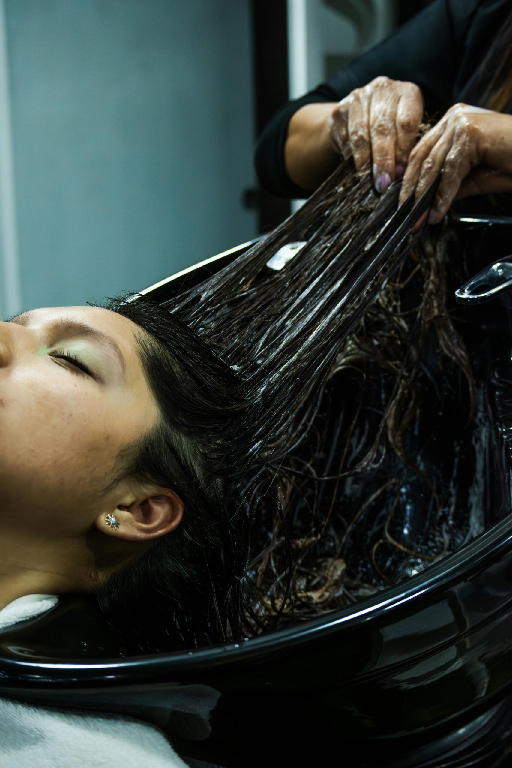 Woman receiving a luxurious hair treatment at a spa in Cuenca, Ecuador, promoting relaxation.